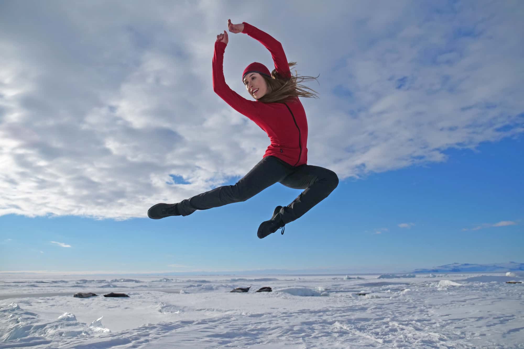 Dancer, Madeleine Graham jumping with Antartic landscape in the background.